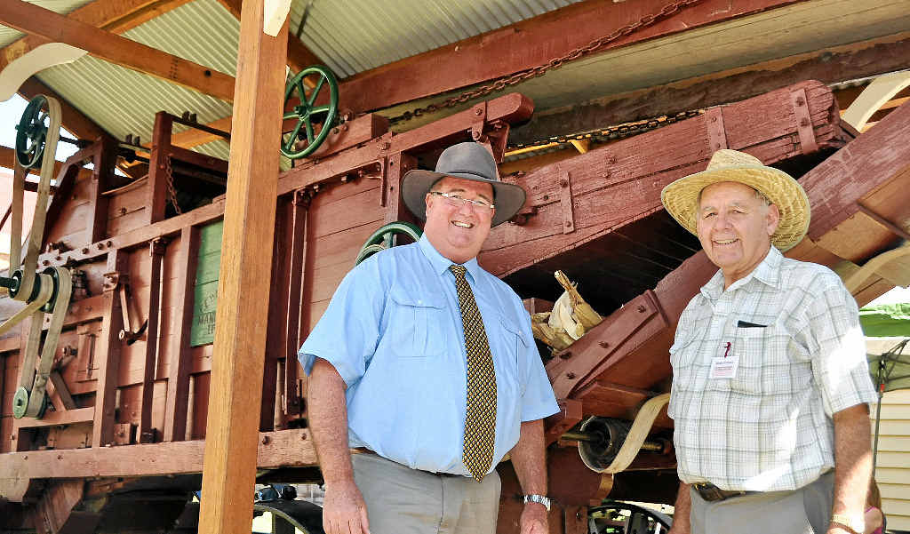 MAGNIFICENT MACHINE: Mayor Peter Blundell with Warwick and District Historical Society volunteer Bernie Stephens and the old corn thresher, which was unveiled at the Pringle Cottage Museum complex yesterday.